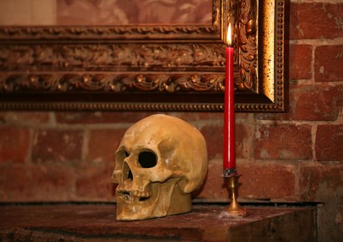 Human skull and candle in an interior