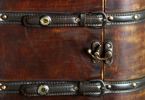 Old wooden suitcase with leather belts