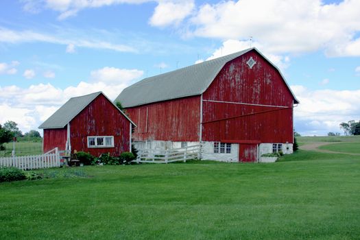 old red barn and shed on a country dairy farm with white fence