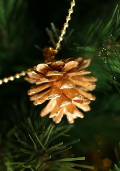Gold pine cones on a chain on a fur-tree