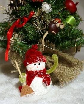 Toy of the snowman in snow and fur-tree