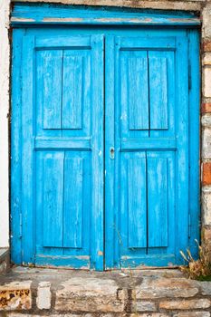 Old weathered blue door in a house in Greece