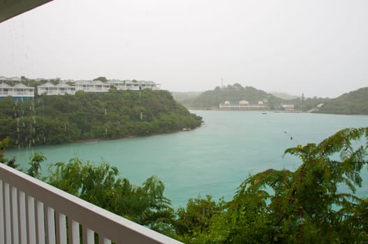 balcony view of Long Bay with resort villas and seascape in Antigua (tropical storm, rainy weather)