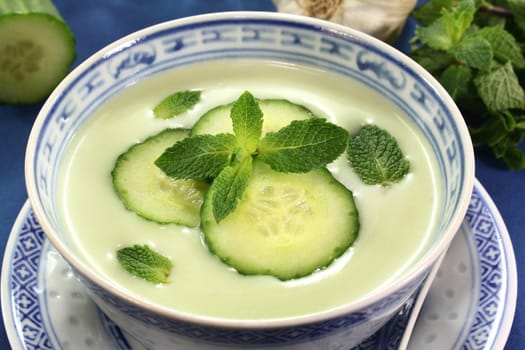 cold cucumber soup with slices of cucumber and mint