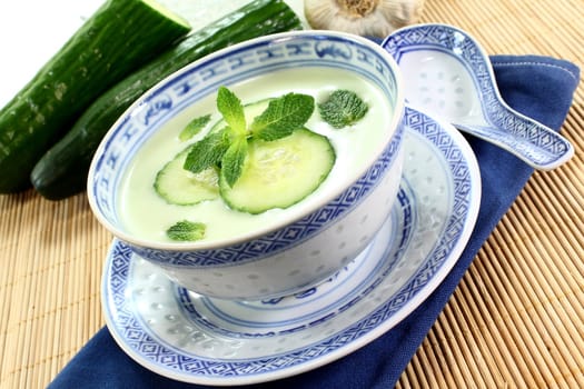 cold cucumber soup with slices of cucumber and mint