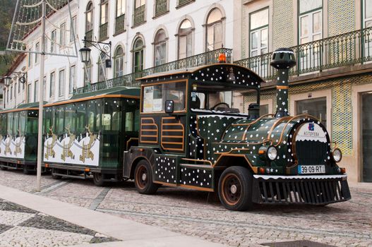 TOMAR, PORTUGAL - DECEMBER 15: sightseeing car train waiting for tourists on Republica Square on December 15, 2011 in Tomar, Portugal. One of the most famous square in Tomar where is the Gualdim Pais statue, founder of the city