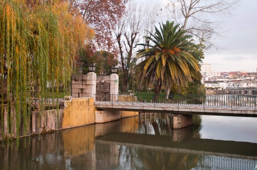 gorgeous Nab�o river and bridge surrounded by trees in the city of Tomar, Portugal