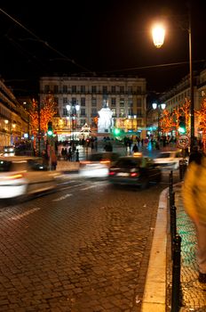 LISBON, PORTUGAL - DECEMBER 19: moving cars traffic and people in motion next to Luis Vaz de Cam�es square during Christmas time on December 19, 2011 in Lisbon, Portugal