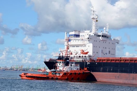 Industrial commercial cargo ships and cranes at sea port.