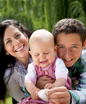Portrait of family mother with son and baby girl smiling and hugging