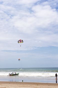 Paragliding pulled by a motorboat on the beach
of  equator