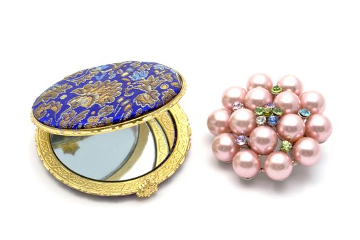 Beautiful cosmetic mirror iand brooch closeup