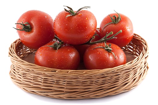 red tomatoes in a wicker basket on white background