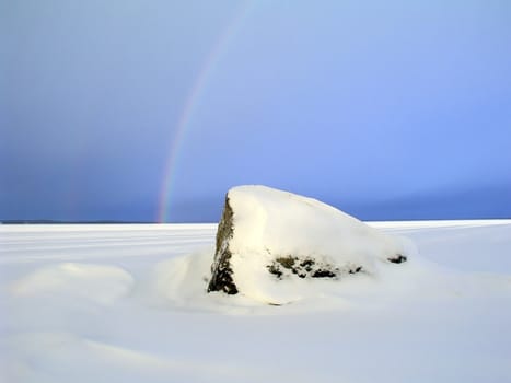 Beautiful landscape of rainbow over the forzen lake