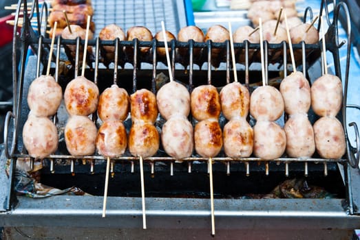 Grill fresh Thai eastern sausages on sticks, taken on sunny day
