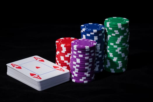 Stacks of Poker Chips with Playing Cards, closeup on black background