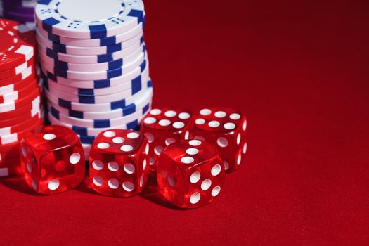 Stacks of Poker Chips with Playing Bones, closeup on red background
