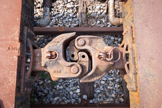 Old and rusty train cabins connector taken from top view on sunny day
