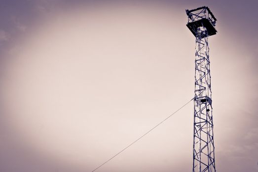 High power electrical lights on a cloudy day with silhouette
