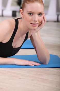 Woman laying on gym mat