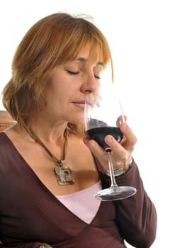 beautiful woman smelling red wineglass in a sofa