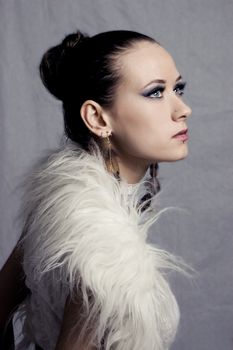 Fashion style model portrait with fur over grey