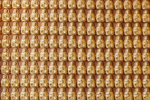 Hundreds of golden Buddha statues background at chinese temple