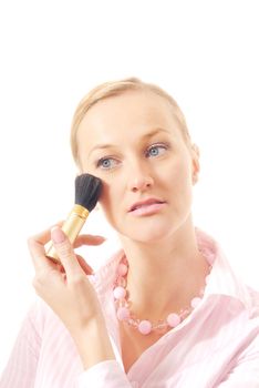 Caucasian woman with makeup brush applying face powder