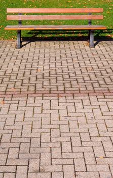 public bench with pavement and grass