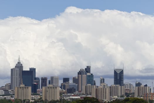 Cityscape of Melbourne, Australia; skyline of city with billowing white clouds and blue skys above and beyond. Location is province of Victoria, Melbourne, Australia;