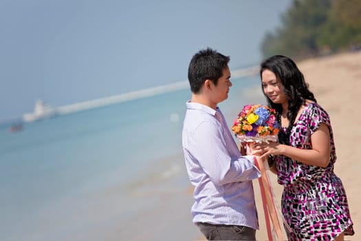 attractive handsome young man giving flowers to his pretty girlfriend