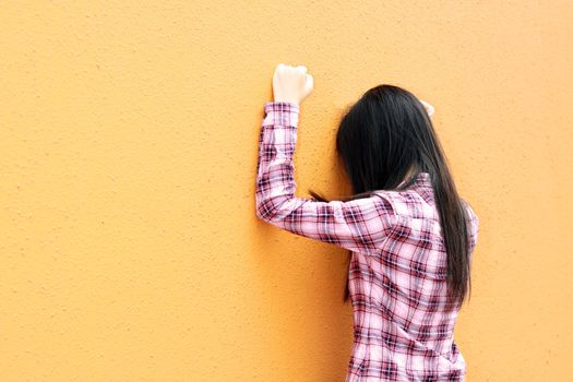 Asian woman very sad and facing the wall