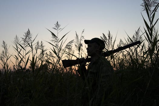 Silhouette of the hunter on a background of a morning dawn