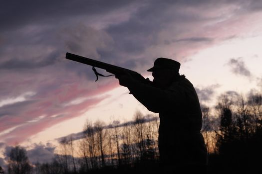 Silhouette of the hunter on a background of a morning dawn