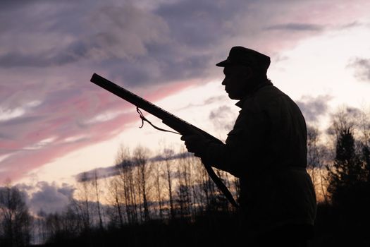 Silhouette of the hunter on a background of a morning dawn