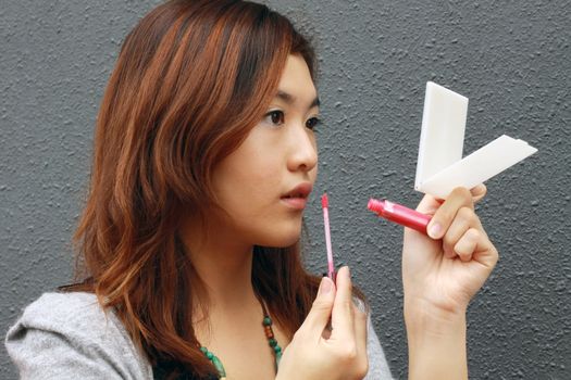 Asian woman doing make-up