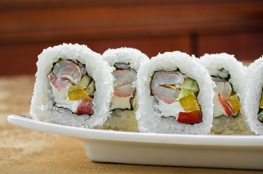 sushi roll of shrimp, cucumber, pepper and sauce, closeup