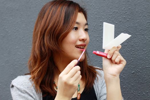 Asian woman doing make-up