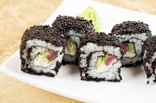 sushi roll with tuna, avacado, sauce and flying fish roe, closeup
