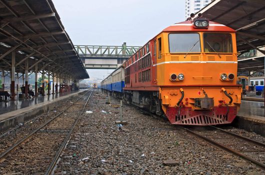Red orange train, Diesel locomotive, on Bangkok railway station platform Thailand