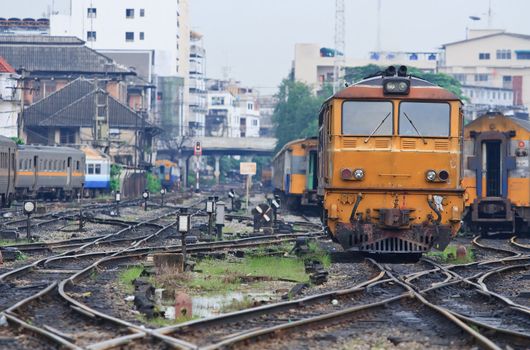 Closeup of Orange Train locomotive approaching to Bangkok Railway Station Thailand with railway junction.