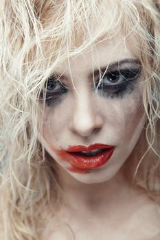 Blond lady with strange makeup. Vertical photo