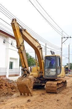 Excavator Loader with backhoe standing in sandpit in village