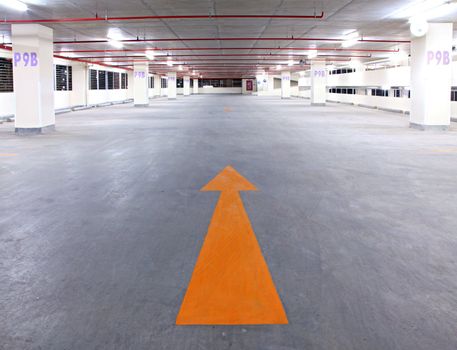 empty parking garage with yellow arrow