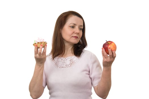 The woman holding in hands an apple and a cake