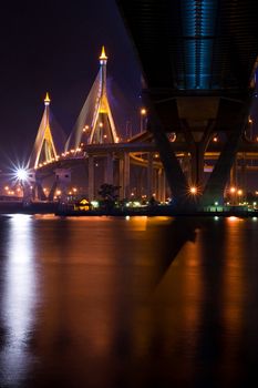 The Industrial Ring Bridge shines at dusk in Thailand with vertical central perspective. The Bridge cross over ChaoPhraya River and Bangkok Harbor