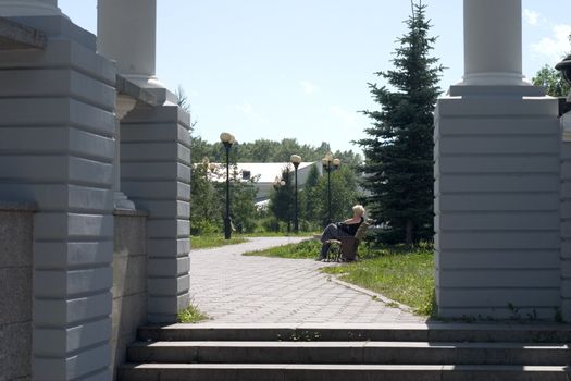 The woman having a rest in park on a bench