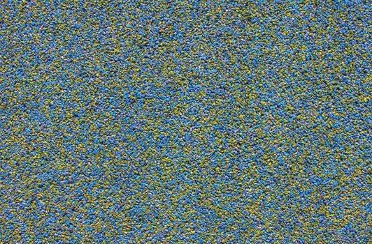A background made of blue and yellow rubber pellets