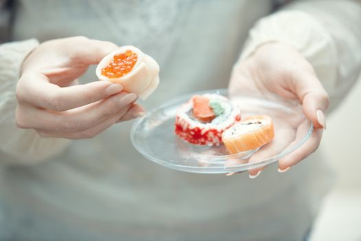 Human hands holding place with sushi