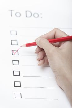 Human hand writing on a checklist document